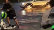 Guys Ride Through Flooded Streets on Electric Scooters