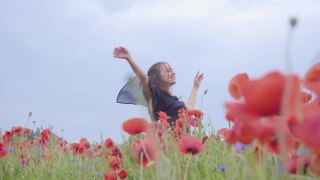 mixkit-girl-dancing-happily-in-a-field-of-flowers-