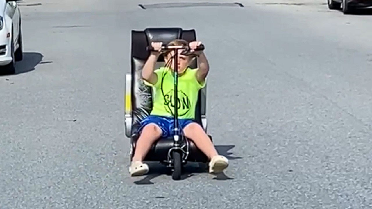Kid loads trashed gaming chair on his scooter and drives home!