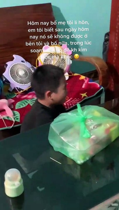 Cậu bé vừa soạn sách vừa khóc nức nở vì ngày mai gia đình phải chia cách, ba mẹ em sẽ không còn bên nhau nữa