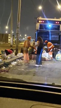 Mujer regala platos de comida a recolectores de basura