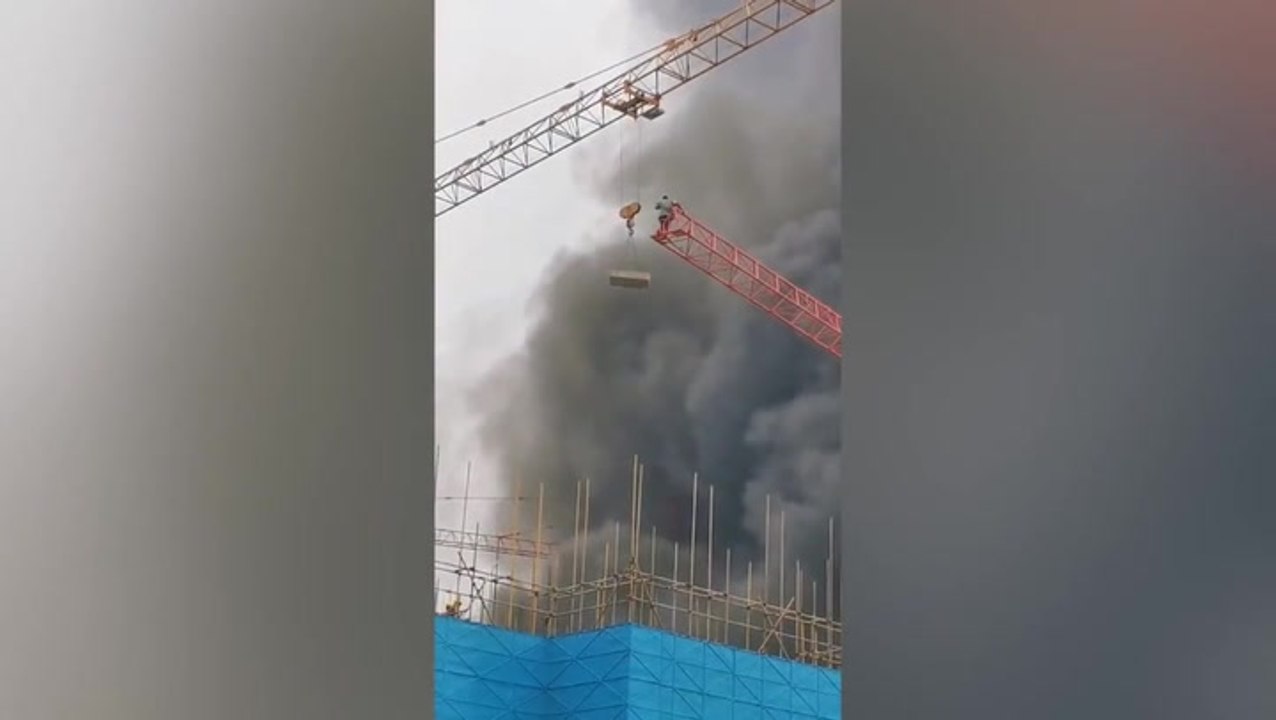 Trapped worker rescued from burning construction site by crane and ...