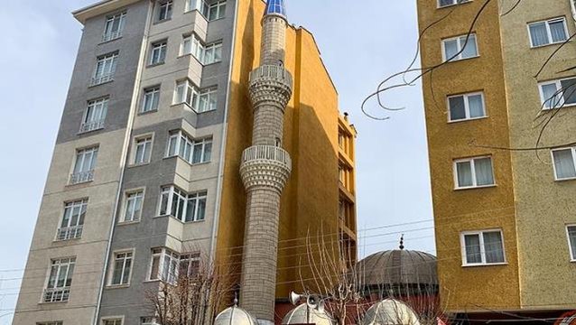 İki apartmanın arasında sıkışıp kalan cami, ilginç görüntüsüyle dikkat çekiyor