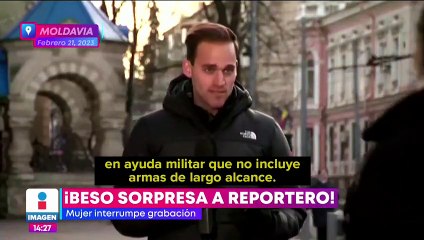 Mujer interrumpe grabación y sorprende a reportero con un beso
