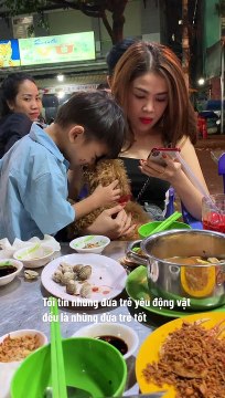 Cậu bé bán kẹo say mê âu yếm chú cún nhỏ của vị khách: Hạnh phúc chỉ đơn giản thế thôi!