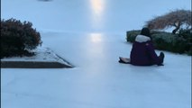 Girls use grocery bags for sledding action in driveway following intense snowstorm