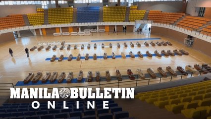 In Italy, the coffins of 64 shipwreck victims are laid out in a local sports hall