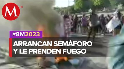 Feministas derriban un semáforo y le prenden fuego para intentar derribar las vallas de seguridad