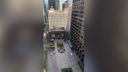 Moment glass falls out of windows from high-rise building near pedestrians below