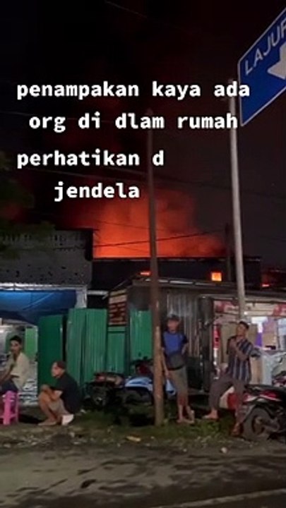 Terlihat ada orang di jendela bangunan yang terbakar