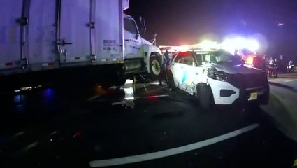 Moment semi-truck smashes into police vehicles attending scene of crash
