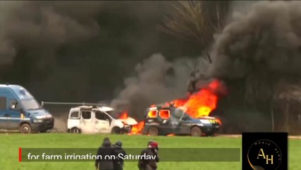 French protesters against farm water reservoir clash with riot police, light car on fire