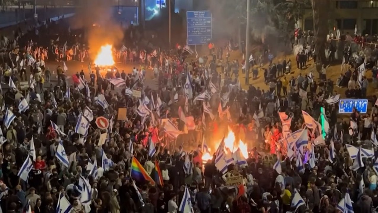Israeli protesters light bonfires and block hig...