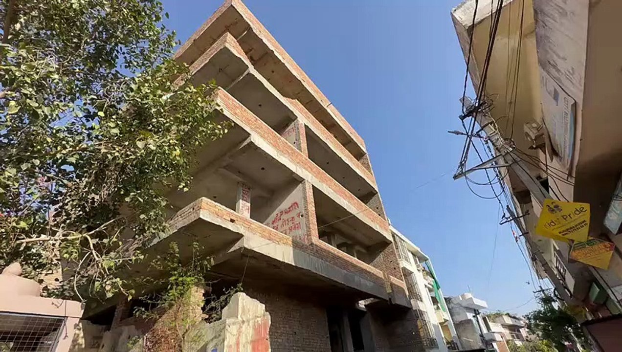 चार मंजिला इमारत के गेटों पर ईंटों की दीवार चुन...