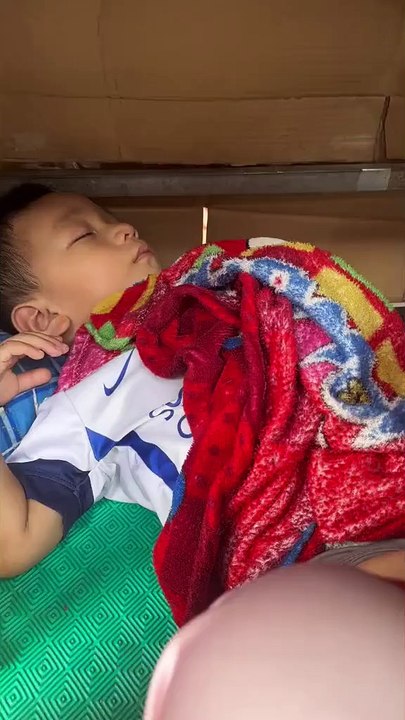 Em bé 2 tuổi theo mẹ bán hàng rong rồi nằm ngủ co ro dưới tủ hàng