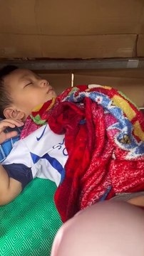 Em bé 2 tuổi theo mẹ bán hàng rong rồi nằm ngủ co ro dưới tủ hàng