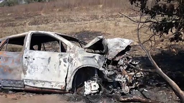 A burnt out car on the road just outside