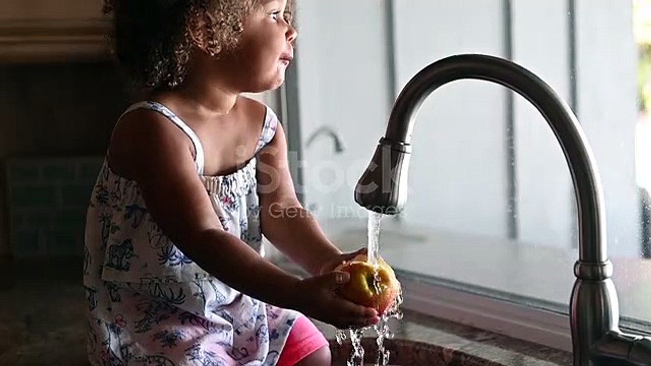 Mixed Race Toddler Eats An Apple In Domestic Family Kitchen Stock Video - Download Video Clip Now