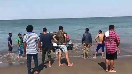 Hondureños intentan sacar carro del mar