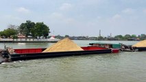 Tugboats and Barge loaded with sand passing at Koh Kret Chao Phraya river Thailand