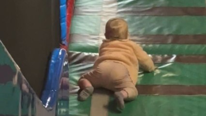 Cute baby has a thrilling way of going down the slide