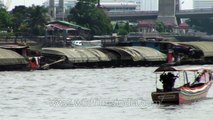 Boats dragging a cargo barge on the Chao Phraya River in Bangkok