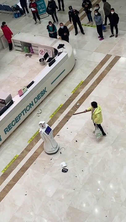 Une femme tabasse un robot