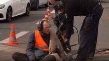 Police use drill to free climate activist who superglued hand to road