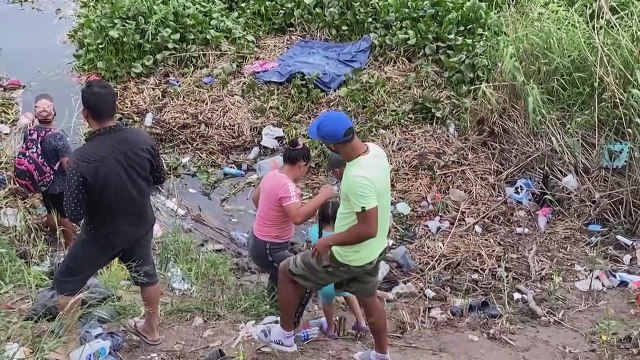 Migrants cross border river between Mexico and US