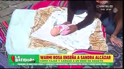 “Hay que saber envolver al bebé”, La Warmi Rosa le enseñan a Sandra Alcázar a cargar en aguayo a un bebé