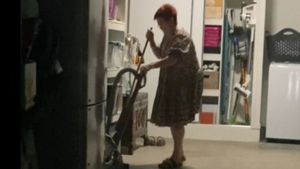 Woman scared of Cane Toad tries to get it out of her garage with a broom