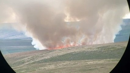 A large fire that broke out on moorland has sent smoke shooting hundreds of feet into the air