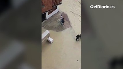 Una mujer intenta cruzar con un niño en un carrito a través de una riada en Molina de Segura