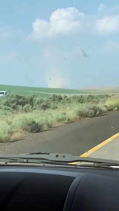 Car Drives Through Highway Crossing Dust Devil