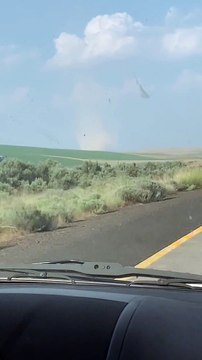 Car Drives Through Highway Crossing Dust Devil
