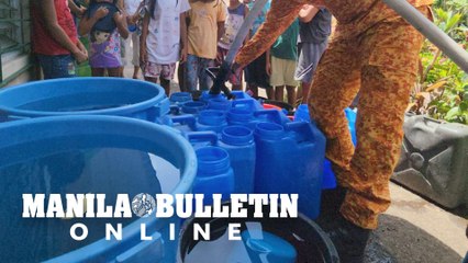 Firefighter supplies water to the families affected by danger zone surrounding Mayon