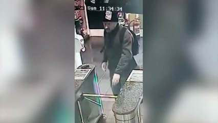 Brazen thief waves at a shop security camera whilst holding a stolen credit card