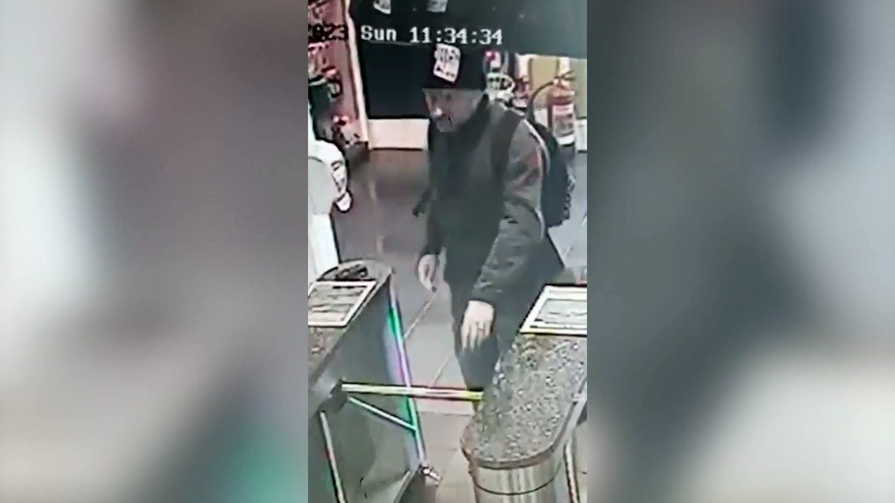Brazen thief waves at a shop security camera whilst holding a stolen credit card