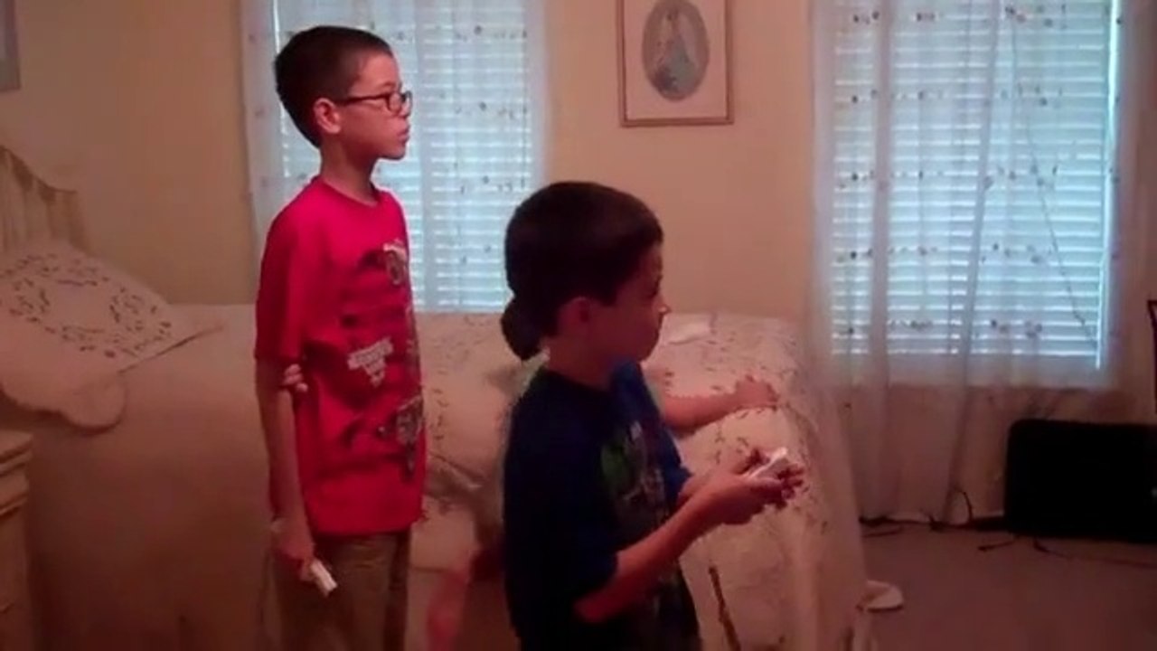 Jonathan & Christopher playing the wii while Anthony plays with rascal