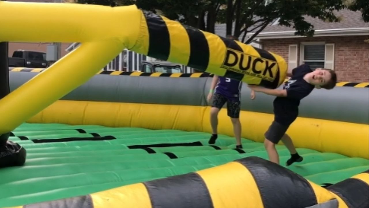 Boy gets hit on face playing on the inflatable rotating obstacle game ...