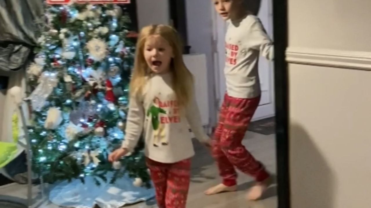 Children wholesomely react on receiving Christmas presents from parents