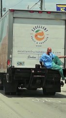 Man Hitches Ride On Back Of Truck