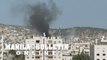 Smoke rises from building as Israeli army vehicles patrol Jenin