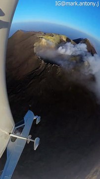 Un avion effectue des manœuvres acrobatiques au-dessus d'un volcan