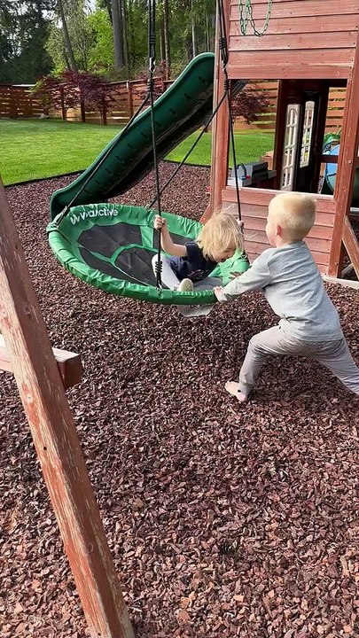Siblings Play on Swing Set