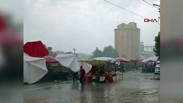 Des parapluies volent sur la place du marché de Bismil sous l'effet de la pluie et du vent