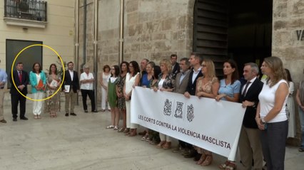 La presidenta de las Cortes Valencianas se aparta de una pancarta contra la violencia machista