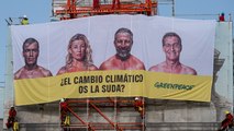 Greenpeace cuelga una lona en la Puerta de Alcalá con la cara de los candidatos: 