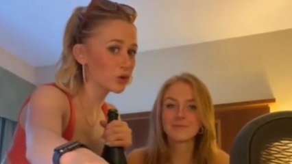 Girl drinking champagne straight from the bottles chokes on it and spews it out