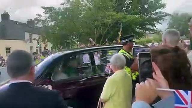 King Charles III and Queen Camilla wave at crowds as they arrive at Brecon Cathedral